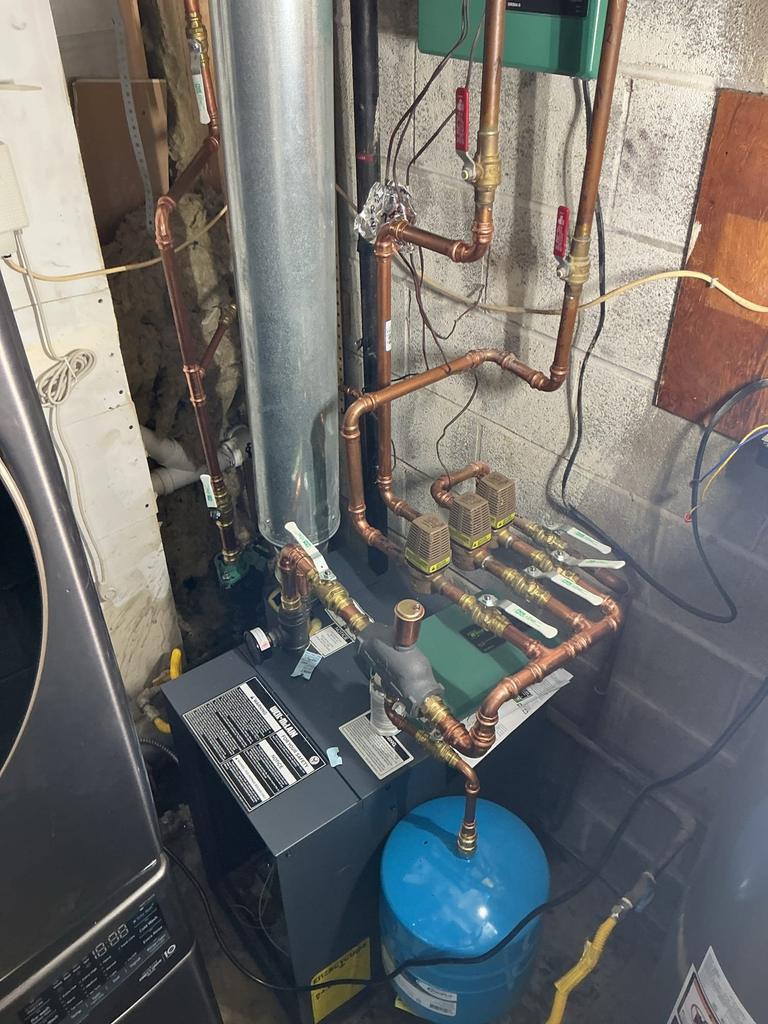 A new Weil-McLain gas boiler that SwiftPro installed in a Northern Virginia basement, with new copper near-boiler piping, three zone valves and a blue expansion tank